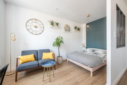 une chambre avec un lit, un canapé et une chaise dans l'établissement Au Nouveau Boulonnais - 4 appartements charmants pour couples, familles et groupe d'amis, vieille ville et centre ville de Boulogne sur Mer, à Boulogne-sur-Mer