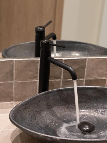 a sink with a faucet in a bathroom at Muse Urban Suites in Athens