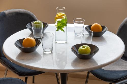 a table with bowls of oranges and a bottle of water at Muse Urban Suites in Athens