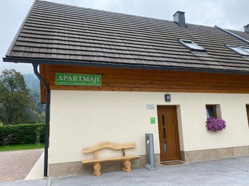 a building with a bench in front of it at Apartmaji Kranjska Gora in Kranjska Gora