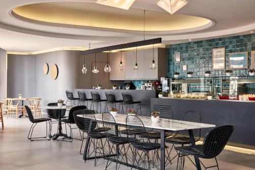 a restaurant with tables and chairs and a bar at Atlantica Caldera Palace in Hersonissos