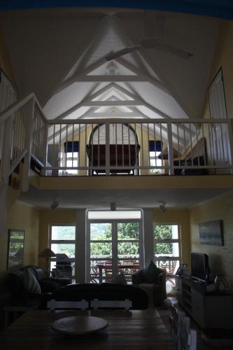 a living room with a balcony and a living room with a couch at The Villa at Caribbean Estates in Port Edward