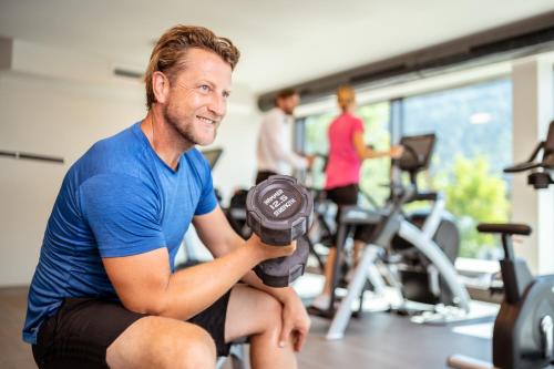 a man sitting in a gym holding weights at Der Postwirt in Söll