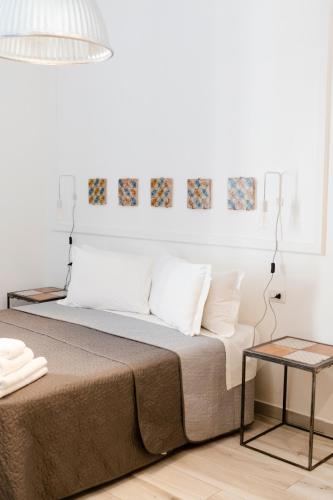 a bed with white pillows and a lamp on it at Borgo Vergini Garden B&B in Naples