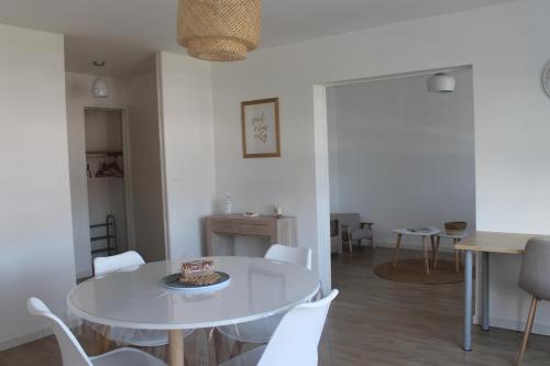 une salle à manger avec une table blanche et des chaises blanches dans l'établissement Appartement Dunkerque proximité plage et centre ville, à Dunkerque