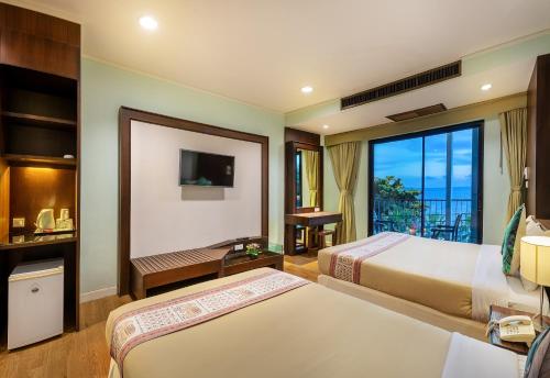 a hotel room with two beds and a balcony at The Jomtien Twelve in Jomtien Beach