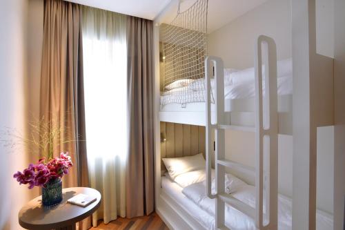 a bedroom with bunk beds and a table with flowers at Das James in Flensburg