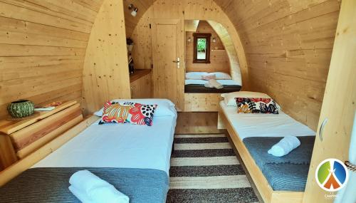 a room with two beds in a log cabin at Camping lago 3 comuni in Alesso