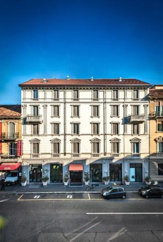 a large white building with cars parked in front of it at Eurohotel in Milan
