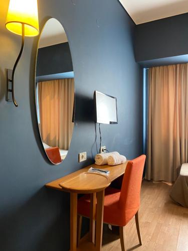 a room with a table and a mirror and a bed at Olympic Hotel in Heraklio Town