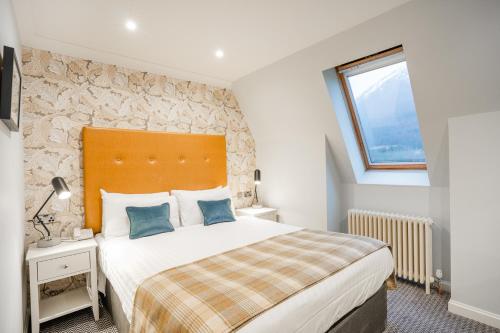 a bedroom with a large bed and a window at The Ballachulish Hotel in Glencoe