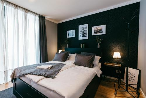 1 dormitorio con 1 cama grande y pared negra en Luxury Downtown Appartement mit Garage, en Graz