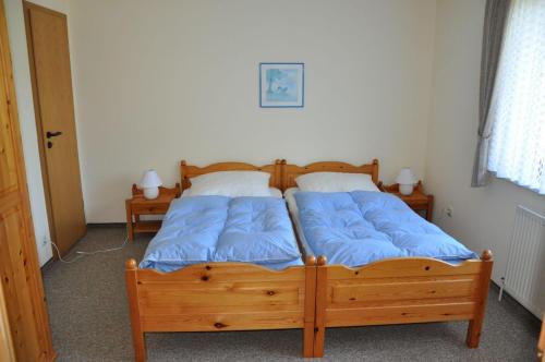 a bedroom with two beds with blue pillows at Ferienhaus Blüthner in Grube