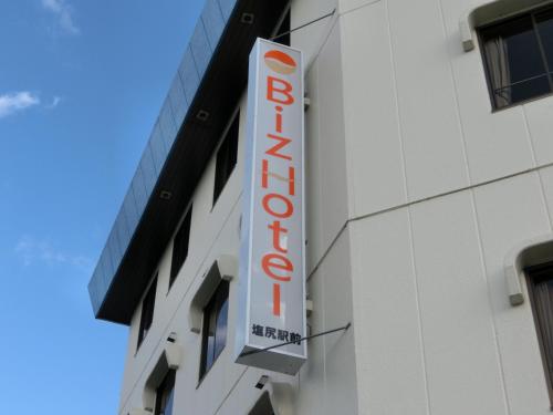 a sign for a hotel on the side of a building at Biz Hotel Shiojiri Ekimae in Shiojiri