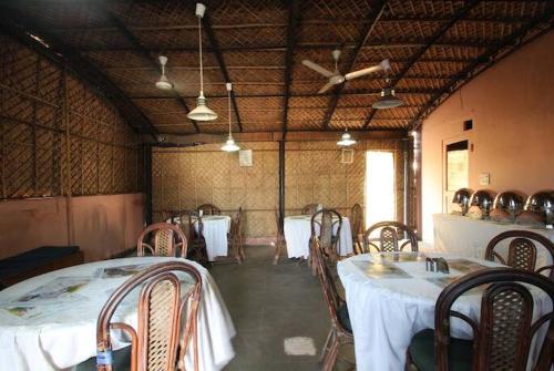 a dining room with two tables and chairs and a ceiling at HOTEL VEER PALACE in New Delhi