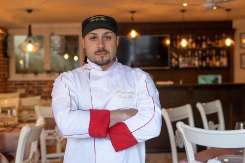 a chef standing in a restaurant with his arms crossed at Pulpudeva Family Hotel in Plovdiv