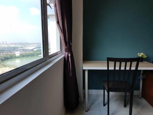 a table and a chair next to a window at Skypod Residence Puchong in Puchong