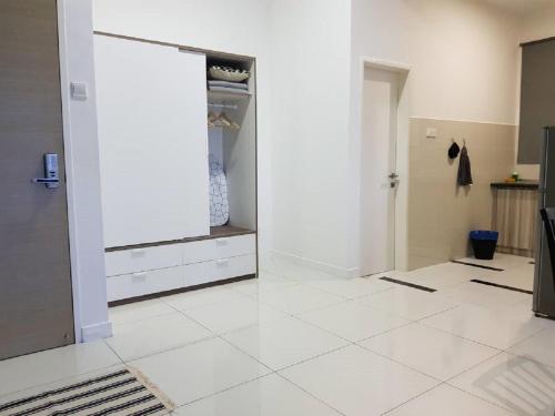 a room with a white tiled floor and an open closet at Skypod Residence Puchong in Puchong