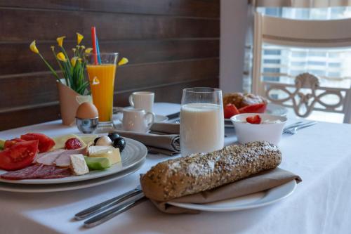 a table with two plates of food and a glass of milk at Pulpudeva Family Hotel in Plovdiv