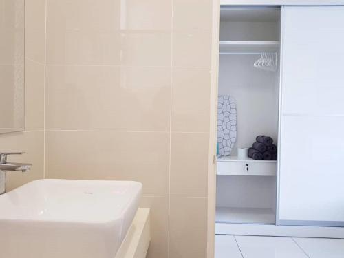 a white bathroom with a sink and a toilet at Skypod Residence Puchong in Puchong
