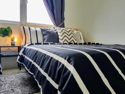 a black and white bed in a room with a window at Skypod Residence Puchong in Puchong