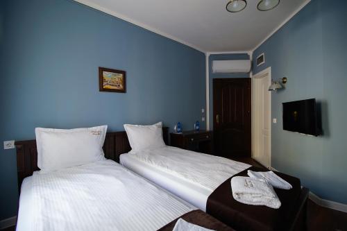 two beds in a hotel room with blue walls at Pulpudeva Family Hotel in Plovdiv