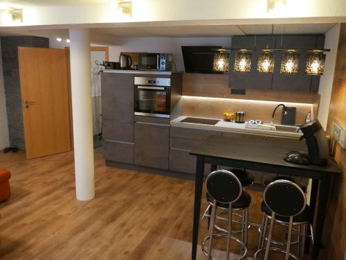 a kitchen with a counter and stools in it at Haus Alexandra in Schwarzenbach an der Saale