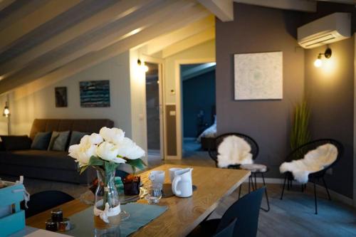a living room with a table with flowers on it at L'Attico del Lago in Sesto Calende