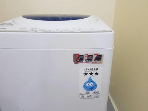 a white washing machine with stickers on it at Skypod Residence Puchong in Puchong