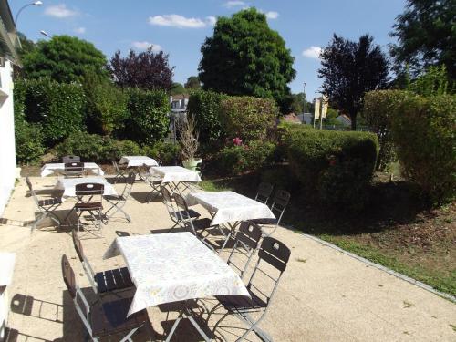 a group of tables and chairs on a patio at Kyriad Chantilly Sud - Luzarches in Chaumontel