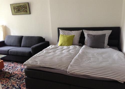 ein großes Bett im Wohnzimmer mit Sofa in der Unterkunft Ferienwohnung Bode in Lübeck