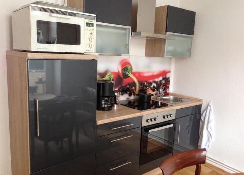 uma cozinha com um micro-ondas e um fogão em Ferienwohnung Bode em Lübeck