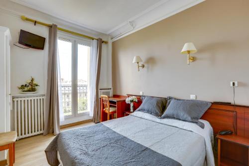 a bedroom with a bed and a large window at Hôtel du Square d'Anvers in Paris
