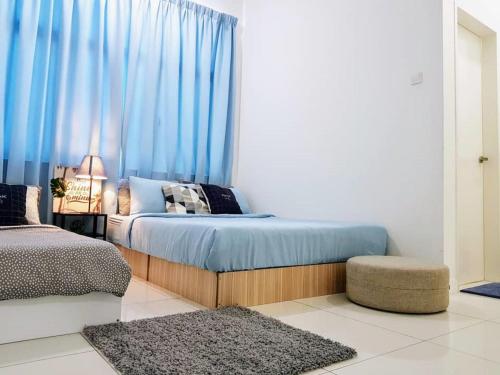 a bedroom with a bed with blue curtains at Skypod Residence Puchong in Puchong