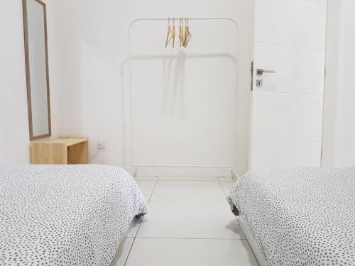 two beds sitting next to each other in a white room at Skypod Residence Puchong in Puchong