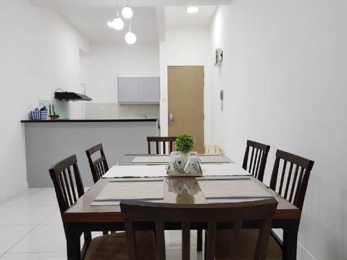 a dining room with a table with chairs and a kitchen at Skypod Residence Puchong in Puchong