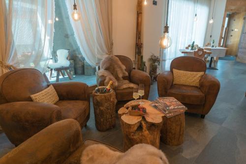 a living room with couches and chairs and a table at Al Baitin - Charme & Nature - in Santa Caterina Valfurva