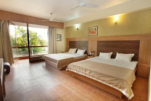 a hotel room with two beds and a window at King's Queen Crown Mandarmoni in Mandarmoni