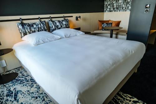 a large white bed in a hotel room at Live Hotels Bordeaux Lac in Bordeaux