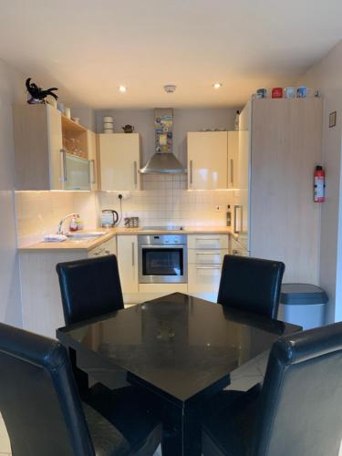 a kitchen with a black table and chairs in it at Boden Heath in Dublin