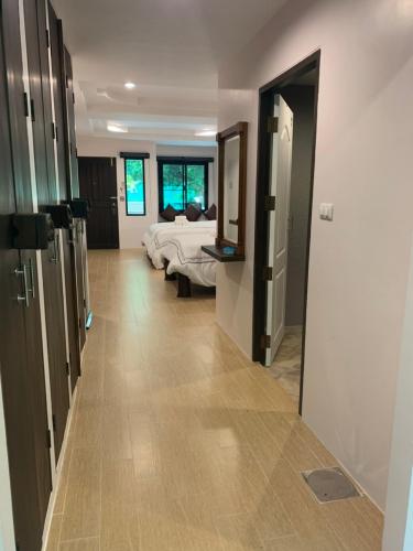 a hallway with a bedroom with a bed and a mirror at Namtok Sarika Resotel in Nakhon Nayok