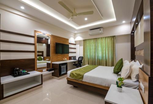 a bedroom with a bed and a desk and a sink at Vanusa Residency in Bengaluru