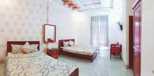 sypialnia z 2 łóżkami i lustrem w obiekcie HOTEL DUY NHẤT w mieście Phú Nhơn