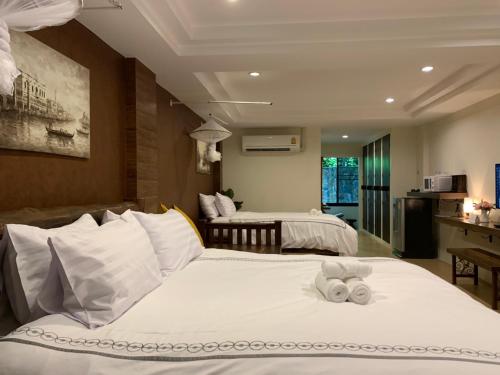 a hotel room with two beds with towels on them at Namtok Sarika Resotel in Nakhon Nayok