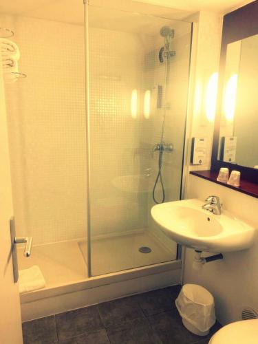 a bathroom with a shower and a sink at Kyriad Chantilly Sud - Luzarches in Chaumontel