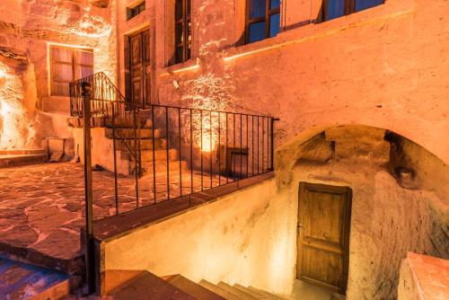a stone building with a staircase and a door at Atilla's Cave Hotel in Nevsehir