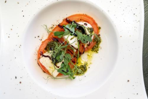a plate of food with a tomato and vegetables at Guildford Manor Hotel & Spa in Guildford
