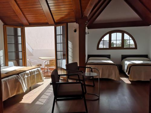a room with two beds and a table and chairs at La Casona Canaria Boutique Home B & B in Agüimes