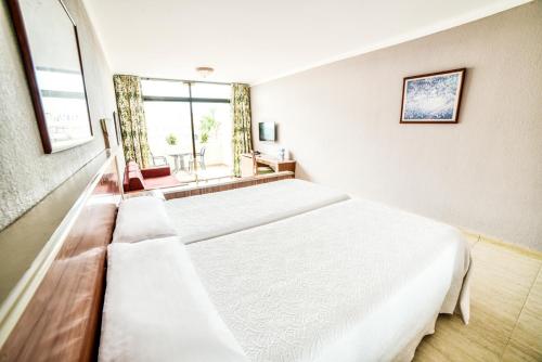 
a hotel room with two beds and a window at Hotel Beatriz Playa & Spa in Puerto del Carmen
