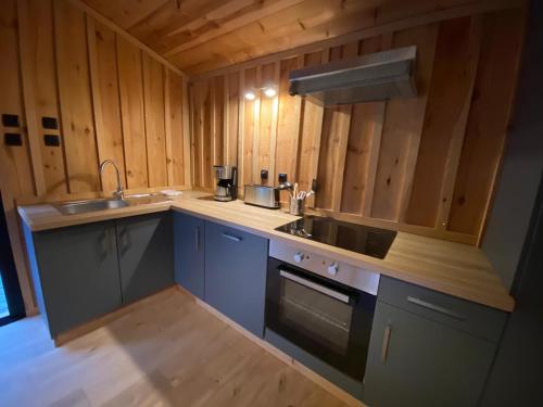 a kitchen with a sink and a stove at Vacances Océan Maison bois Lège Cap Ferret 1-4p in Lège-Cap-Ferret